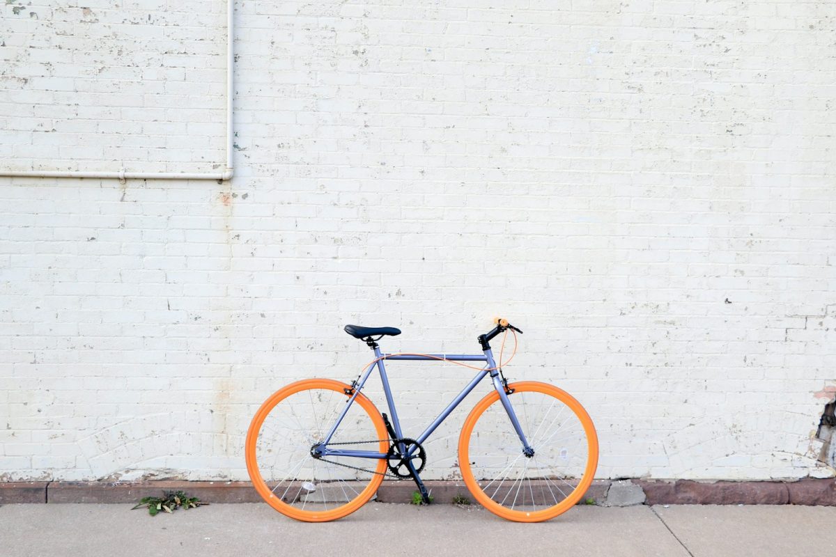 vélo coloré posé le long d'un mur blanc